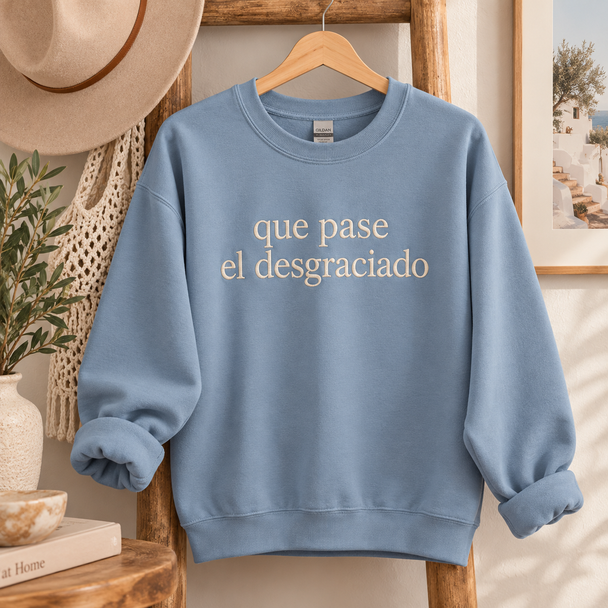 Blue crewneck sweatshirt with cream Que Pase El Desgraciado embroidery