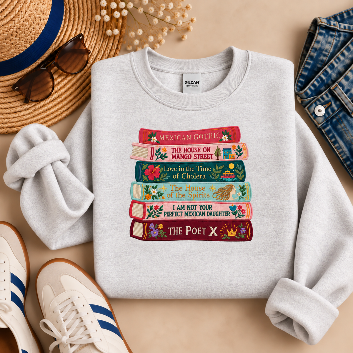 Ash gray embroidered Latina literature sweatshirt displayed with a straw hat, sunglasses, denim jeans, and sneakers.