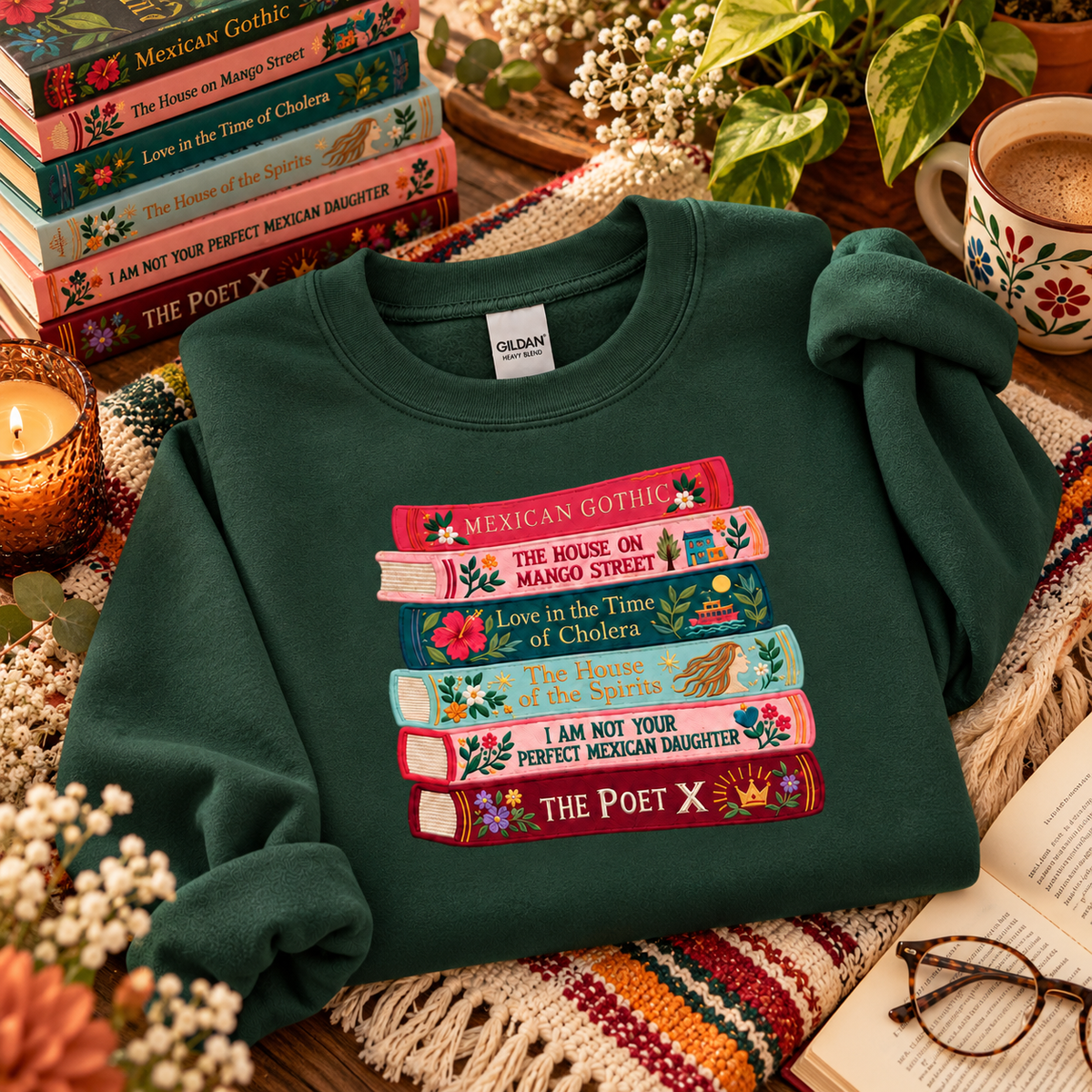 Forest green embroidered book stack sweatshirt styled with colorful books and cozy reading accessories.