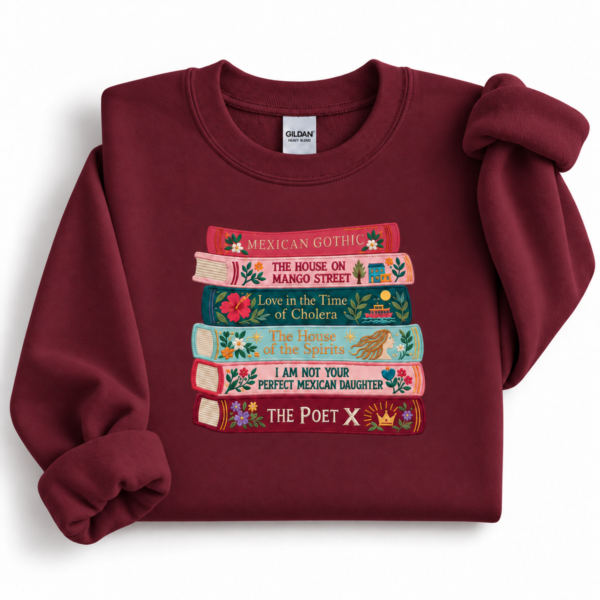 Garnet Gildan 18000 crewneck sweatshirt featuring a colorful embroidered stack of six books by Latina and Latin American authors.