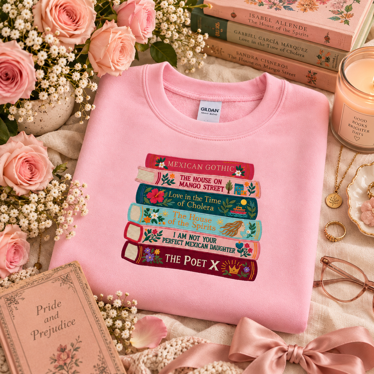 Light pink embroidered book stack sweatshirt surrounded by pink roses, books, and feminine accessories.